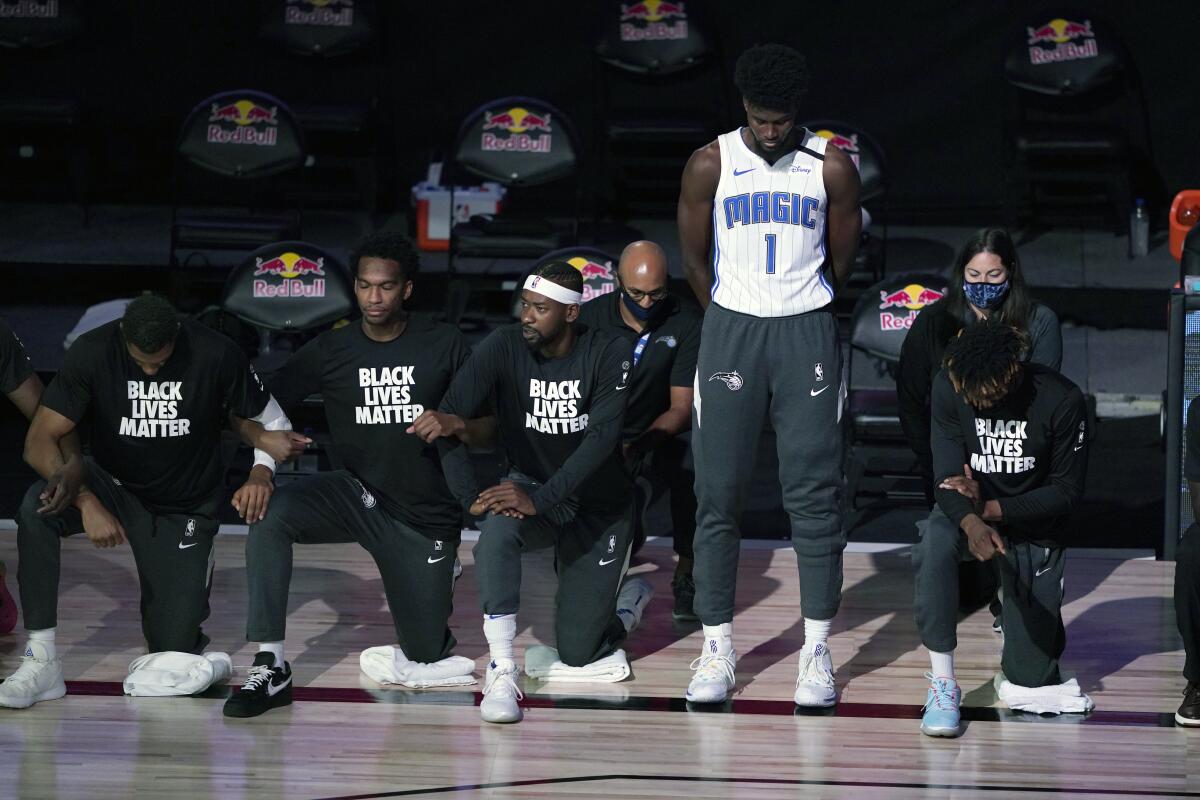 Orlando's Jonathan Isaac stands as others kneel during the national anthem before a game Friday.