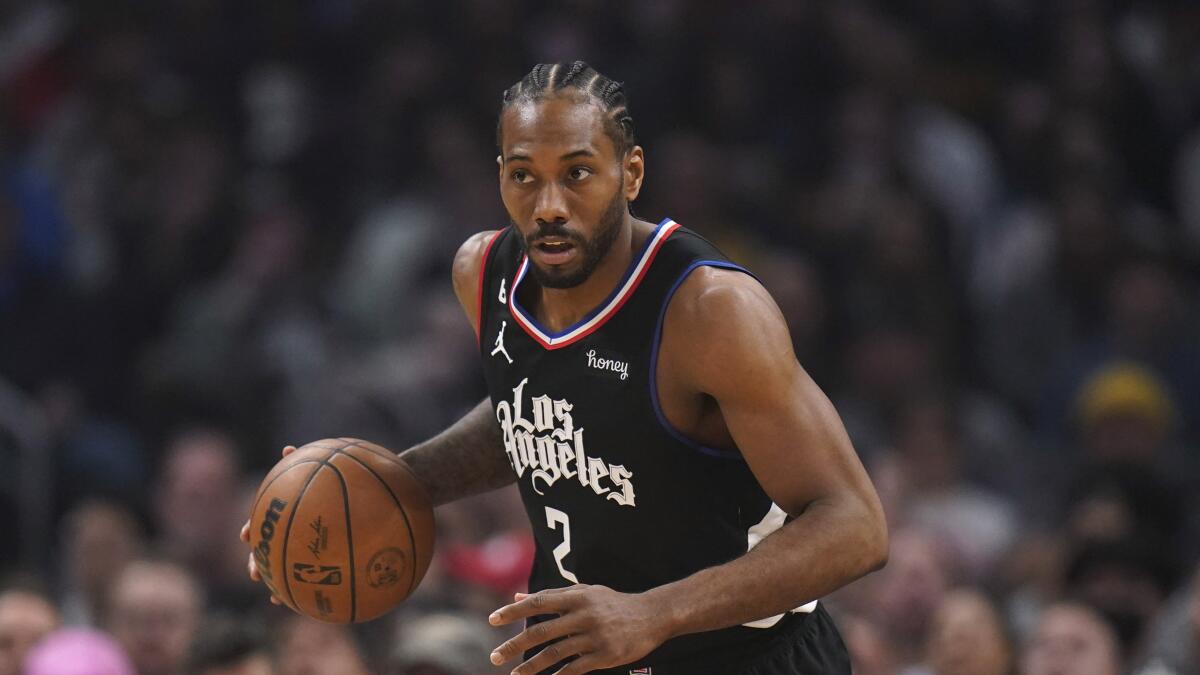 Clippers forward Kawhi Leonard dribbles the ball up court.