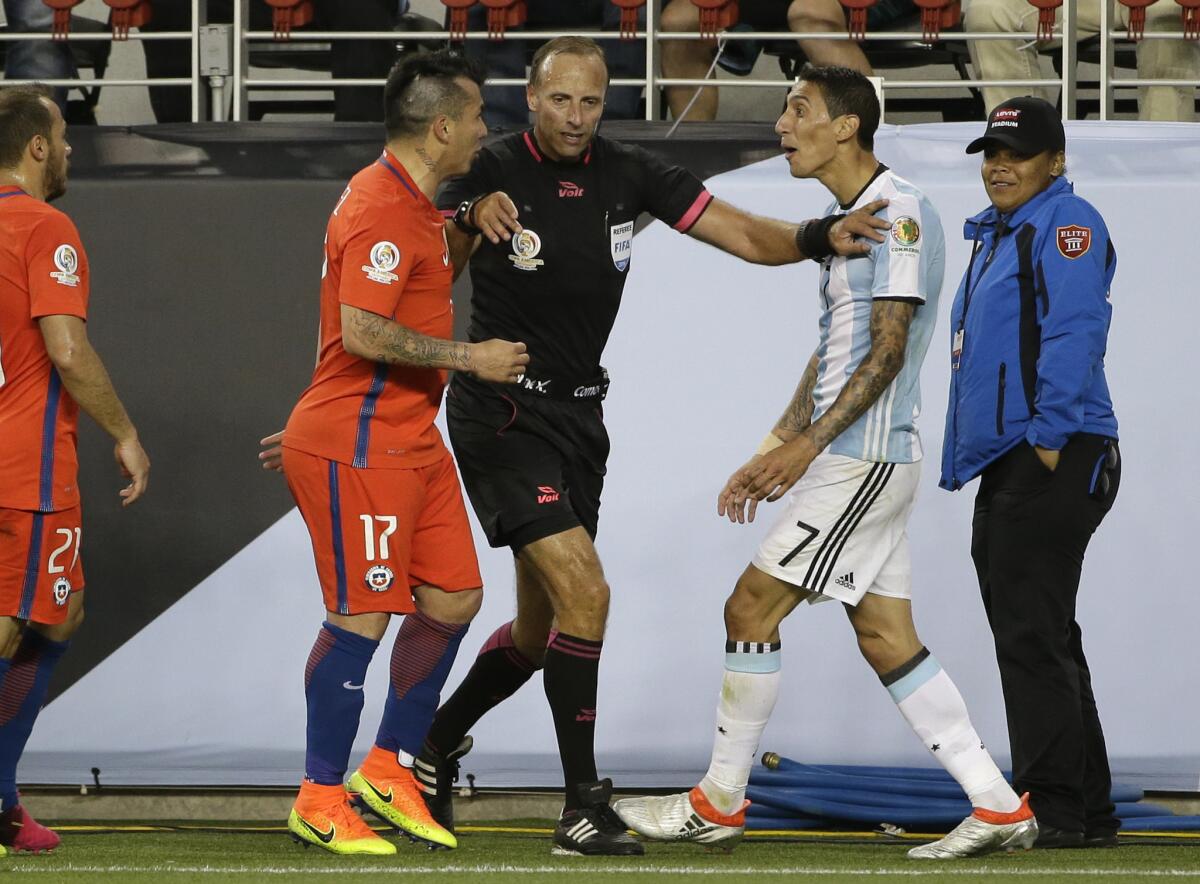 Referee Daniel Fedorczuk separates Chile's Gary Medel, left, and Argentina's Angel Di Maria during a Copa America Centenario match.