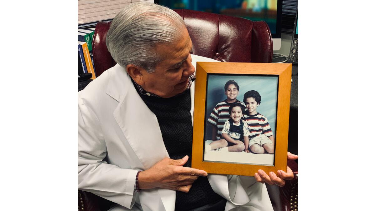 Dr. Xavier Caro with a photo of his murdered children. From left is Joey, 11, Christopher, 5, and Michael, 8. He has a fourth son, who is now 20.