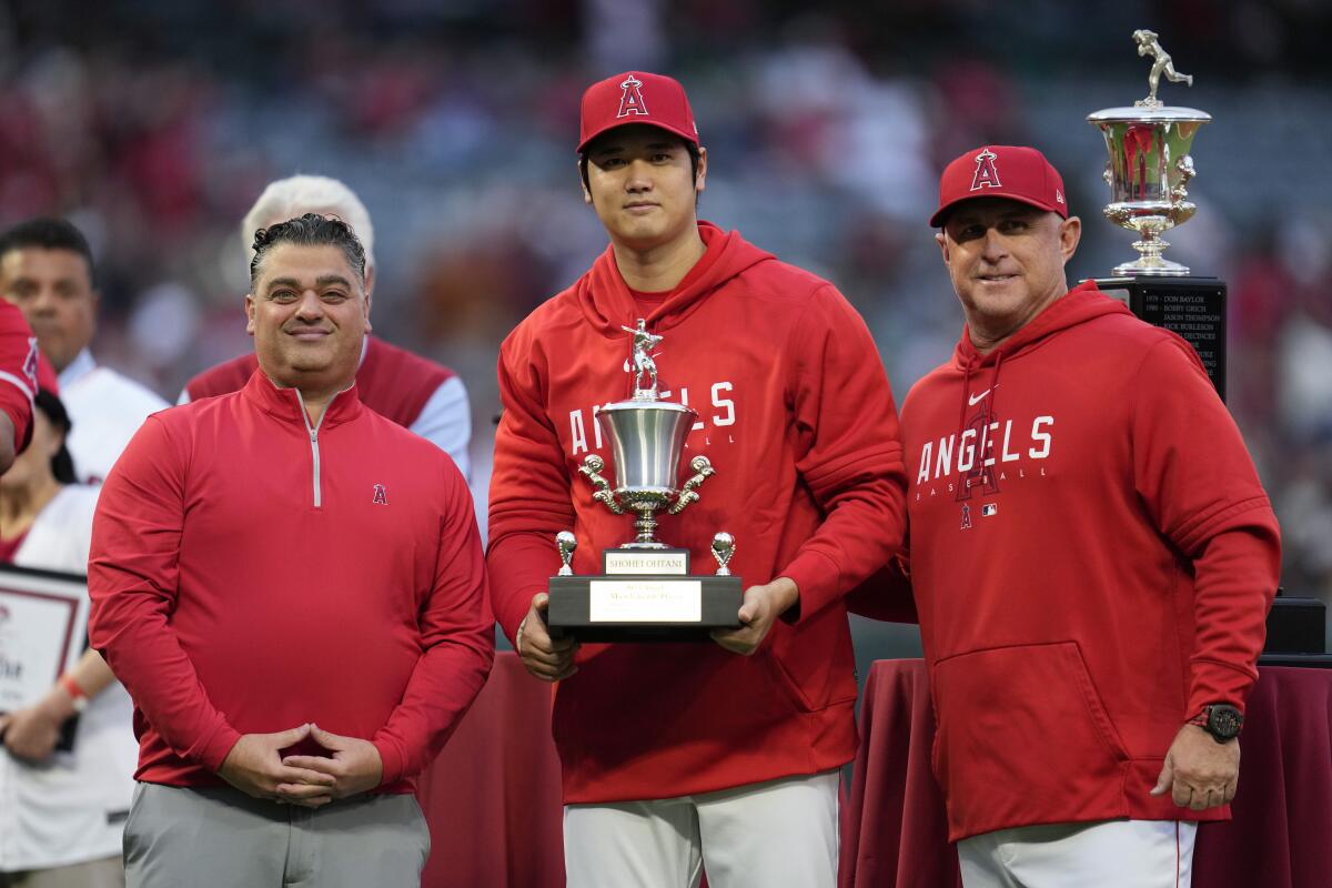 Los Angeles Angels' Shohei Ohtani, center, poses with general manger Perry Minasian.