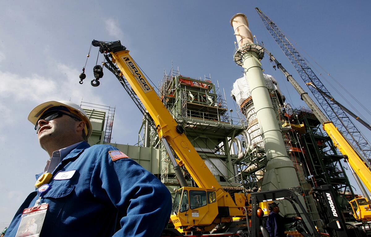 Chevron oil refinery manager Gary Yesavage stands next to a major piece of equipment that is being overhauled in El Segundo.