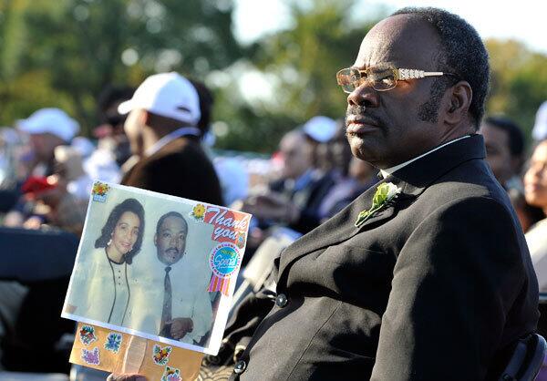 Rev. Cal H.P. Merrell poses with an image of Dr. Martin Luther King, Jr. and his wife Coretta Scott King.