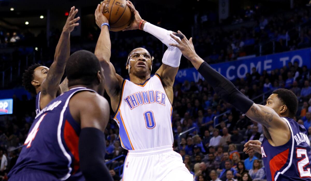Thunder guard Russell Westbrook (0) goes to the basket between a trio of Hawks in the first half Friday night.