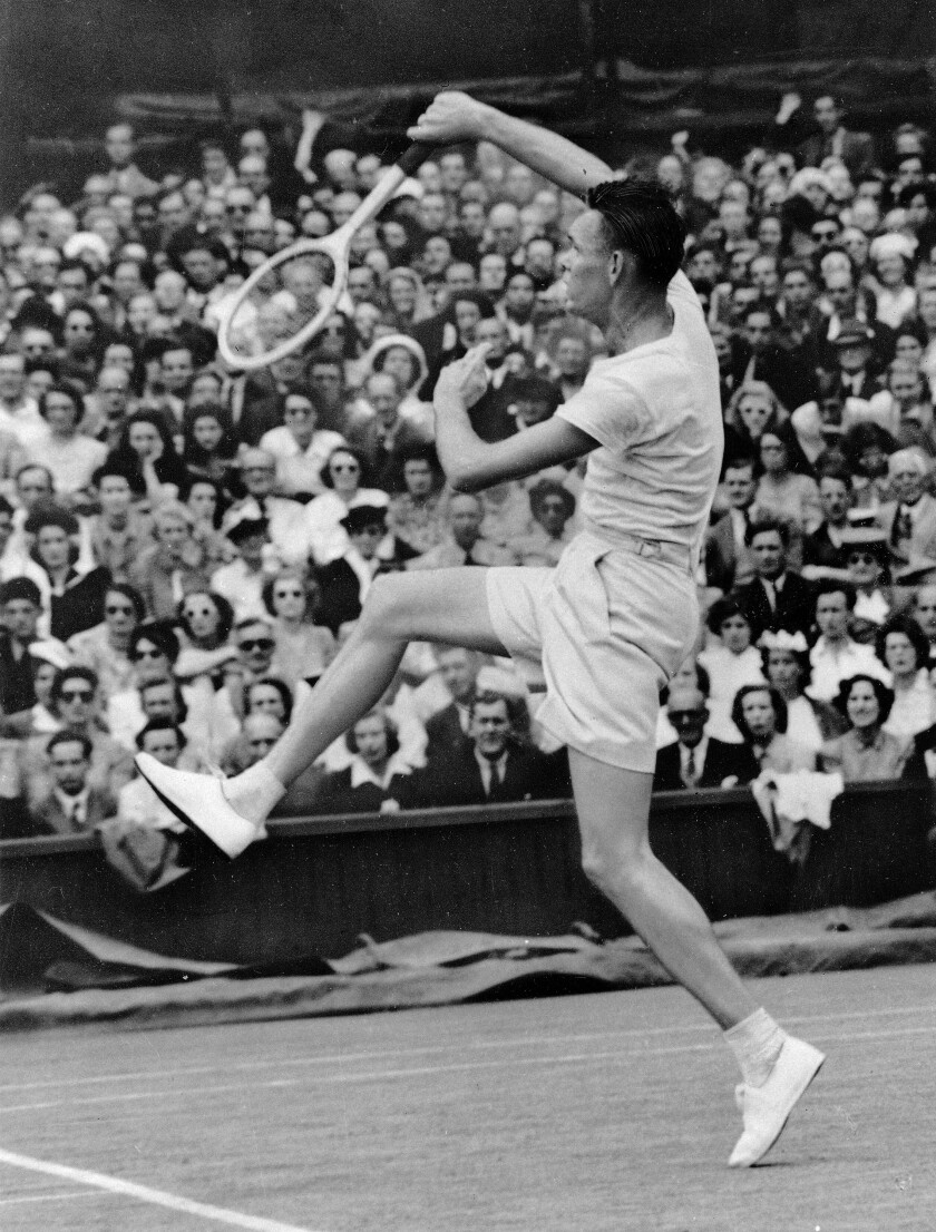 Jack Kramer smashes a return shot during a semifinal match at Wimbledon in 1947.