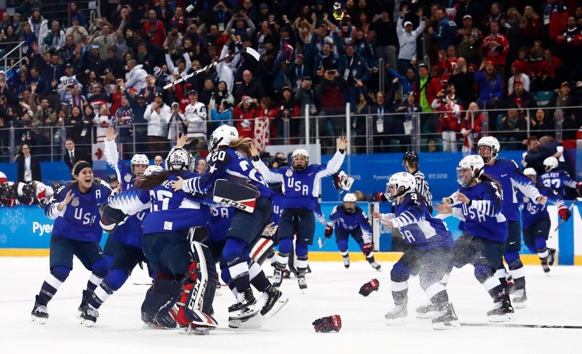 USA celebrates after defeating Canada in a shootout to win the gold in women's hockey