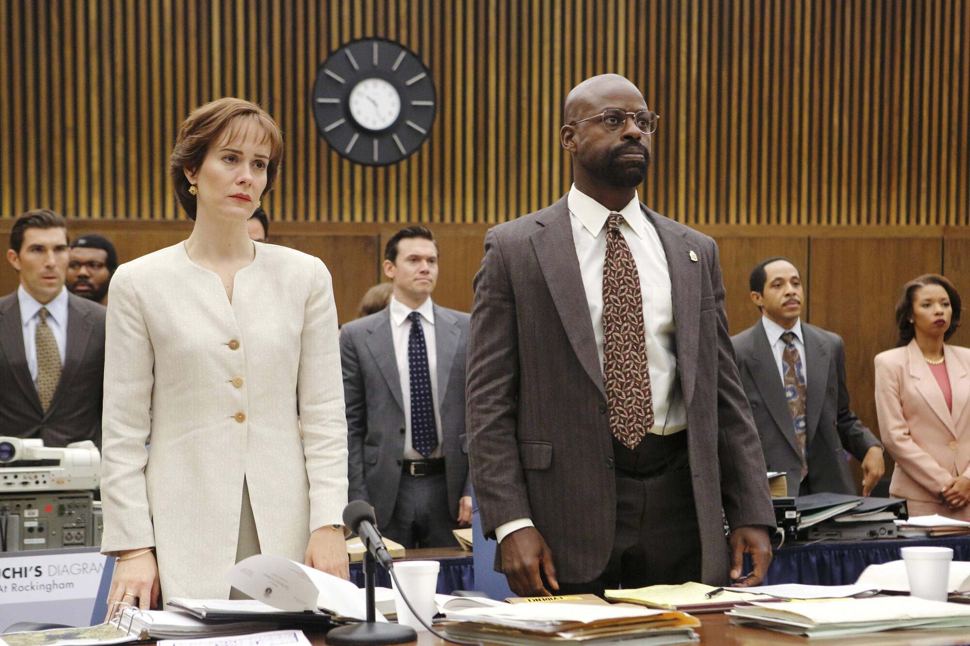 Actors portray two prosecutors standing in court in the 1990s.