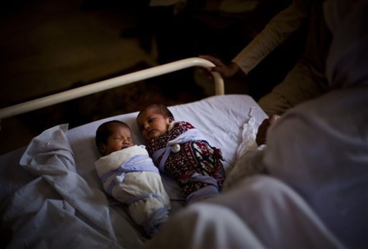 In this photo taken on May 26, 2009, new born twins babies from internally displaced family from Swat valley, sleep at the Mardan Medical Complex in Mardan, Pakistan. Overwhelmed by more than two million people, who have escaped from the mountainous northwest where the army is battling Taliban insurgents, Pakistan's rundown health care system is near collapse, say health officials. (AP Photo/Emilio Morenatti)