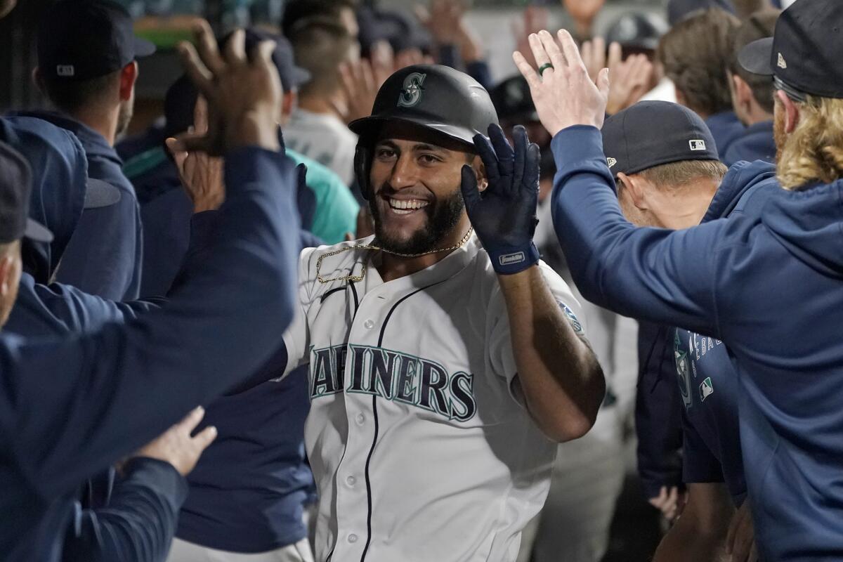 Seattle Mariners' Abraham Toro is greeted in the dugout after he hit a grand slam off Houston Astros relief pitcher Kendall Graveman during the eighth inning of a baseball game, Tuesday, Aug. 31, 2021, in Seattle. The Mariners won 4-0. (AP Photo/Ted S. Warren)