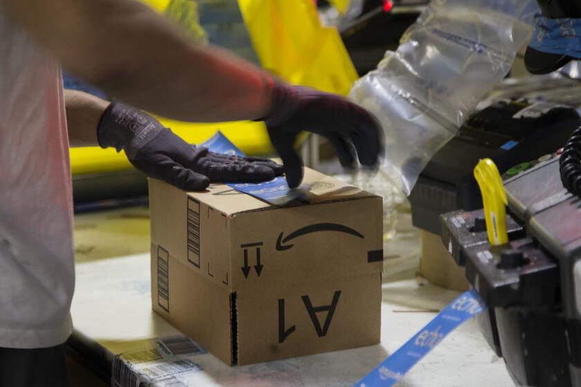 SAN BERNARDINO, CA - NOVEMBER 28, 2016: A worker tapes a box while packing items on Cyber Monday at the Amazon Fulfillment Center on November 28, 2016 in San Bernardino, California.(Gina Ferazzi / Los Angeles Times)