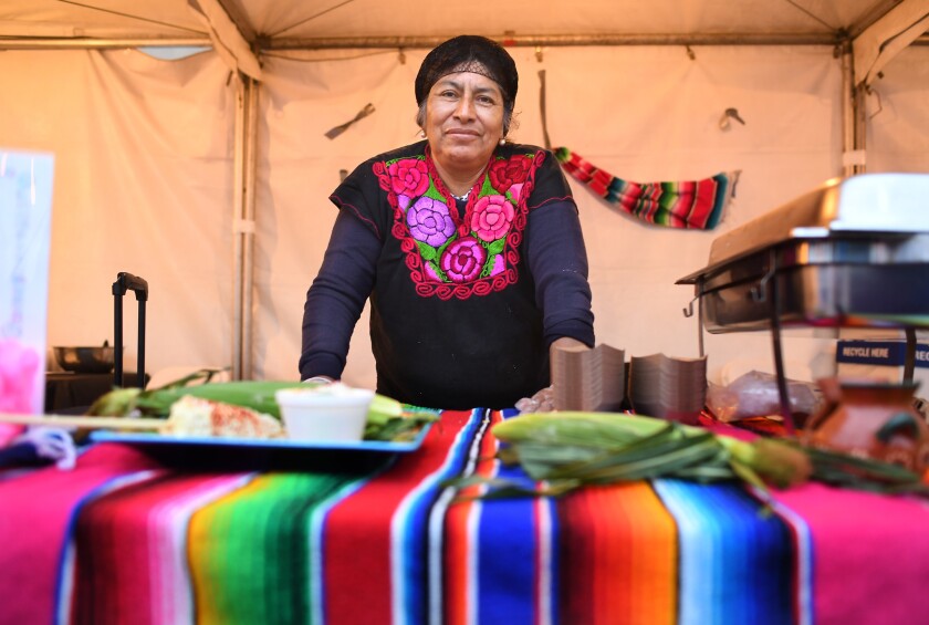 Sidewalk vendor Merced Sanchez awaits customers at her food booth at the recent Taste of Boyle Heights event.