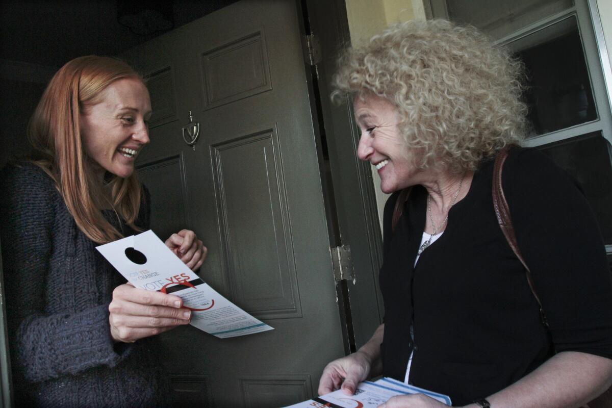 Lauren Meister, right, talks with Nicole Paterson, left, while campaigning for term limits on elected officials in West Hollywood. Meister was sworn in as a West Hollywood council member on Monday.