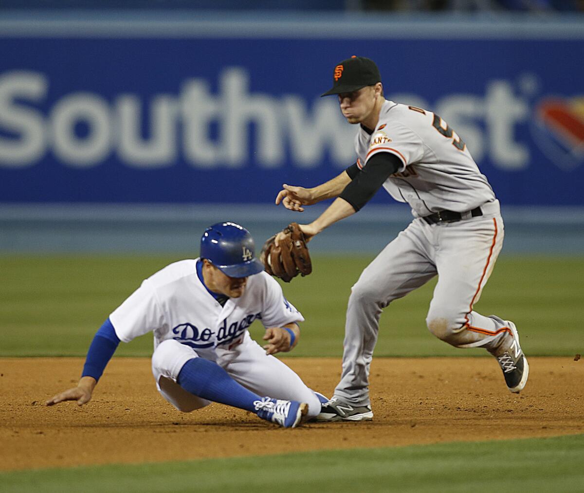 Dodgers outfielder Enrique Hernandez gets caught in a rundown at second base as teammate Howie Kendrick scores in the fourth inning. The Dodgers lost to the Giants, 2-1.