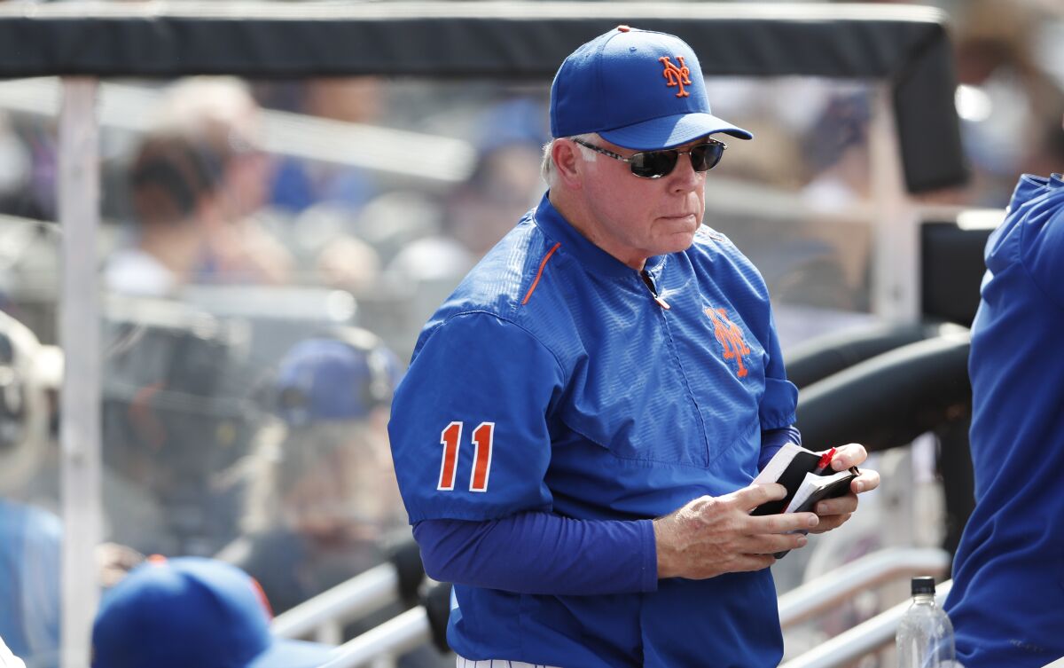 New York Mets manager Buck Showalter (11) stands in the dugout during a baseball game against the Seattle Mariners during the sixth inning, Sunday, May 15, 2022, in New York. (AP Photo/Noah K. Murray)