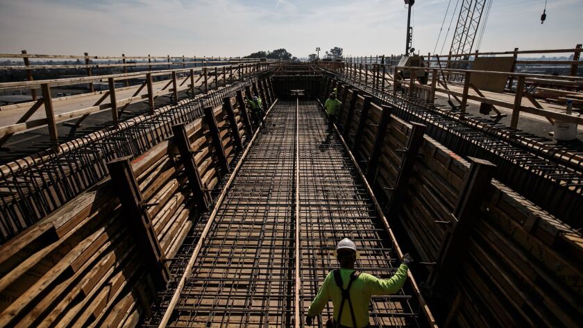 Construction workers in 2017 at a section of viaduct for the high-speed rail line in Fresno County. The project ballooned to $44 billion over budget and 13 years behind schedule.