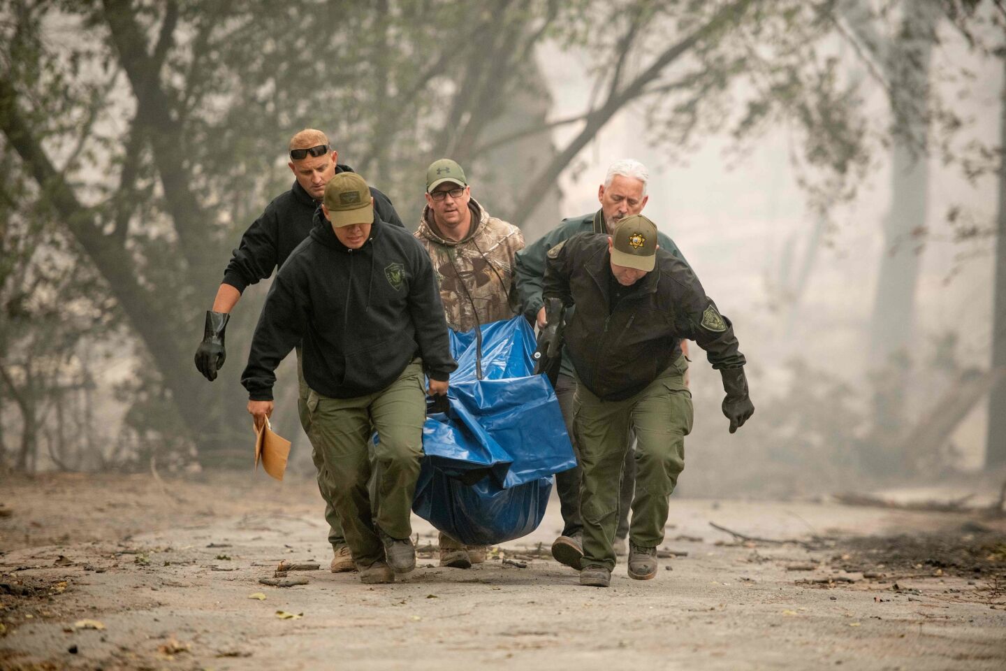 Yuba County sheriff's officials carry a body away from a burned residence in Paradise.