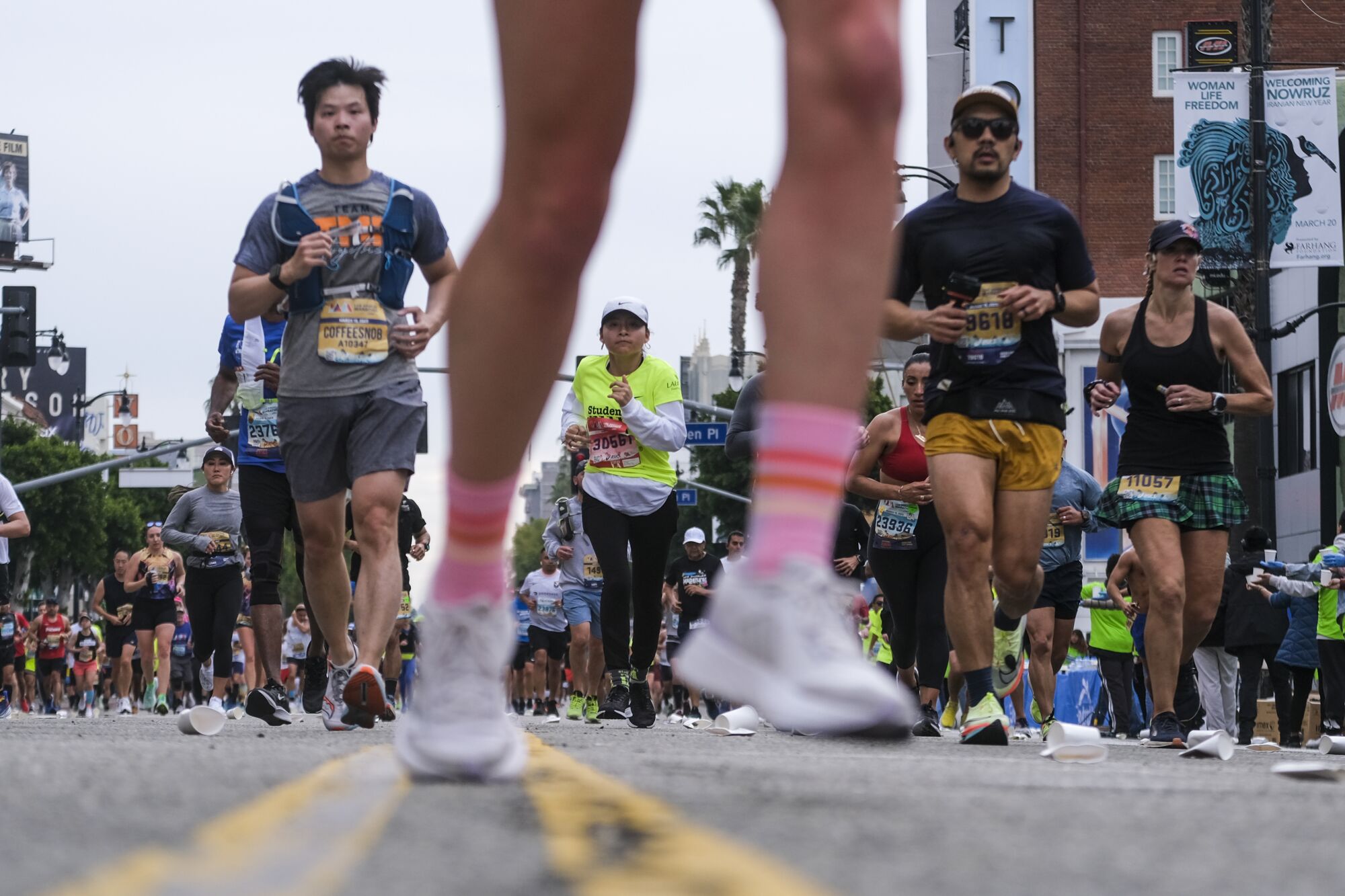 Several people run along Hollywood Boulevard.