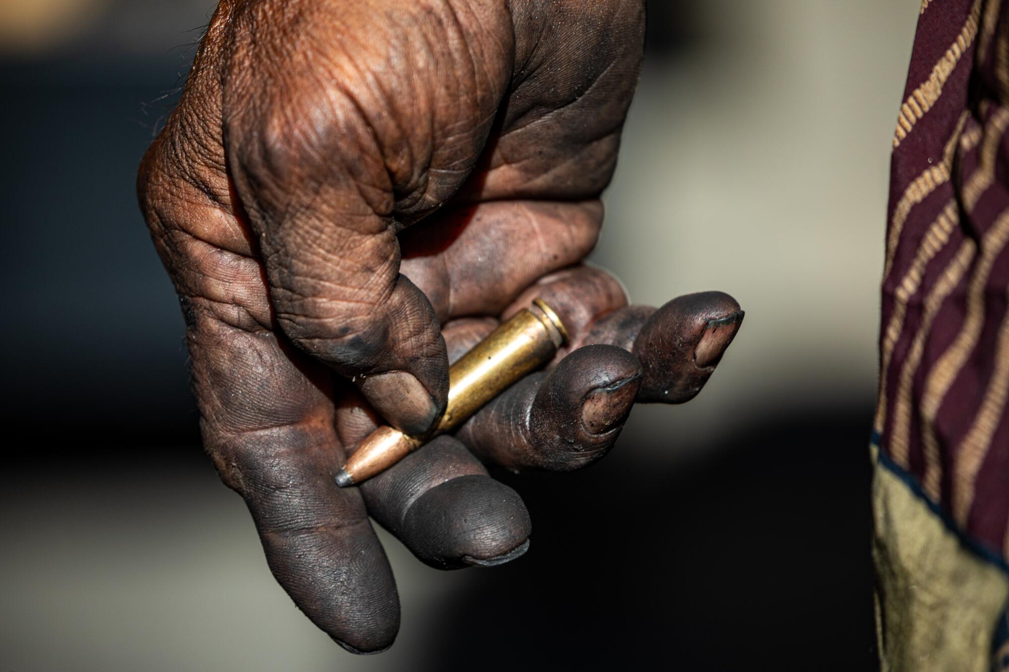 A hand holds a bullet.