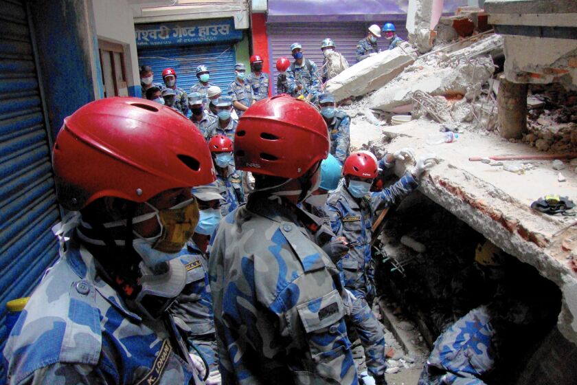 A rescue team searches under a collapsed building in the Gongabu neighborhood of Katmandu, Nepal, for a body in the aftermath of the earthquake.