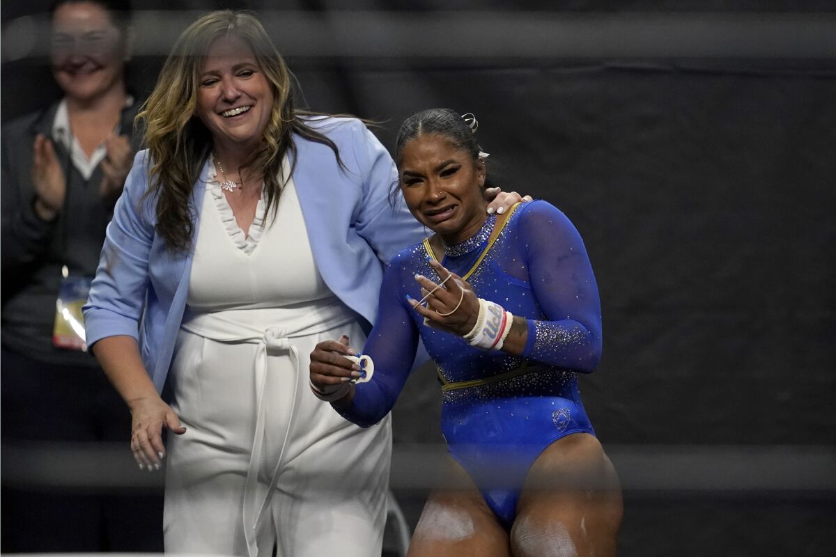 UCLA's Jordan Chiles rejoices with coach Janelle McDonald after earning a perfect score on the bars April 13, 2023.