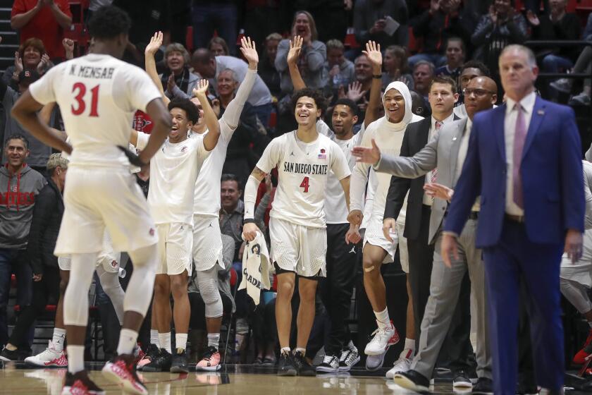 Aztecs players cheer after the Aztecs' Matt Mitchell dunks the ball in the final seconds of the first half against Cal Poly at the Viejas Arena on Saturday, December 28, 2019 in San Diego, California.