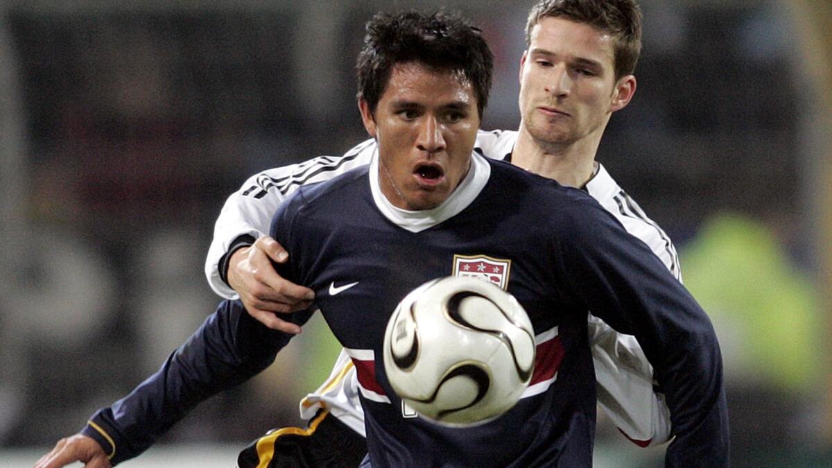U.S. national team forward Brian Ching, front, battles against Germany's Arne Friedrich during an international friendly match in 2006. Ching, who retired last year, says he isn't bitter that he never got a chance to play in a World Cup match.
