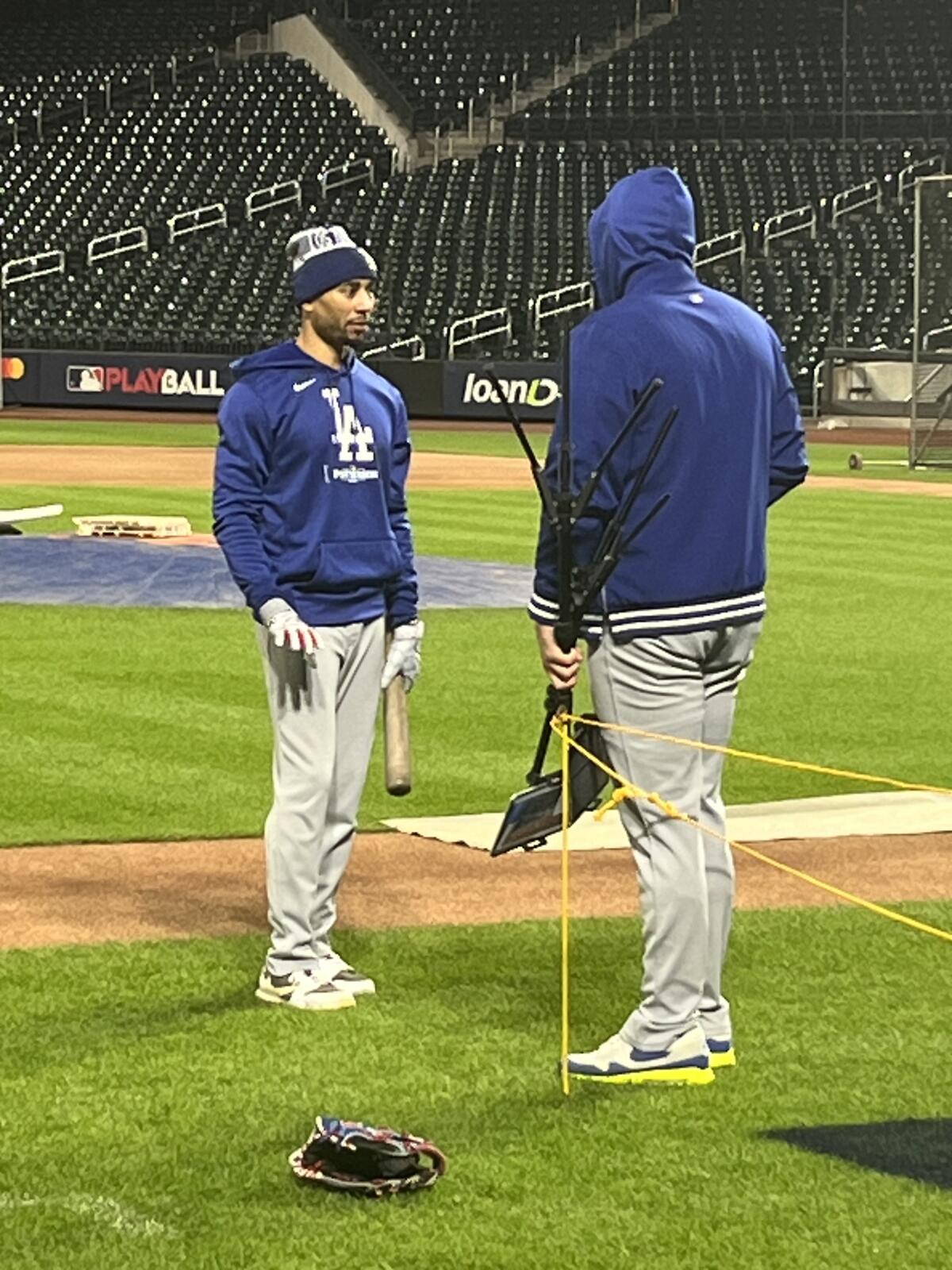 Dodgers right fielder Mookie Betts speaks with Dodgers batting coach Aaron Bates after practicing.