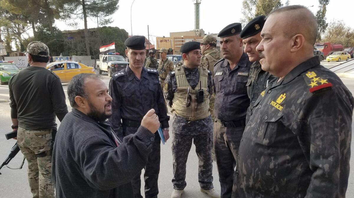 Residents greet Mosul police Chief Wathaq Hamdani as he tours a neighborhood on the city's east side Wednesday.