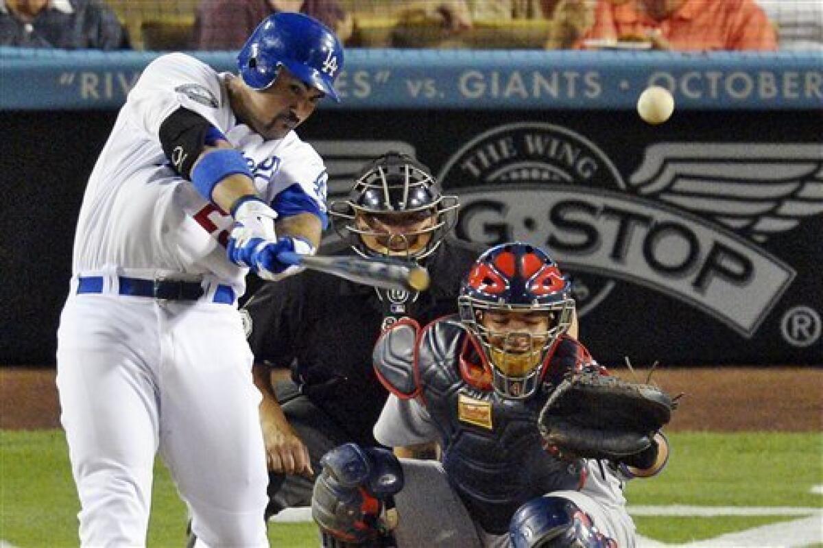 Los Angeles Dodgers' Adrian Gonzalez, left, hits an RBI double as St. Louis Cardinals catcher Yadier Molina, lower right, and home plate umpire Doug Eddings watch during the first inning of their baseball game, Thursday, Sept. 13, 2012, in Los Angeles. (AP Photo/Mark J. Terrill)