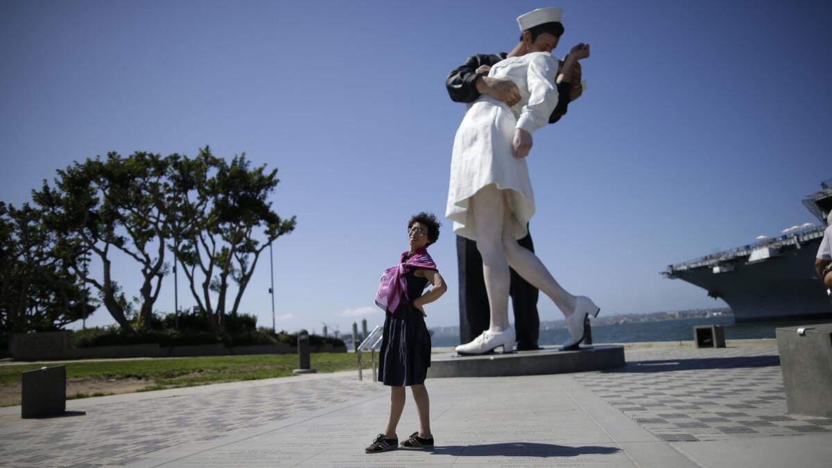 A tourist from China stands in front of the sculpture "Unconditional Surrender" in San Diego on Sept. 18, 2015.