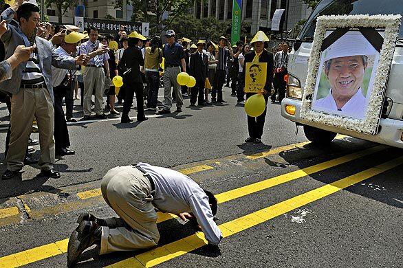 A man bows before a portrait of former South Korean President Roh Moo-hyun during the funeral for Roh in Seoul.