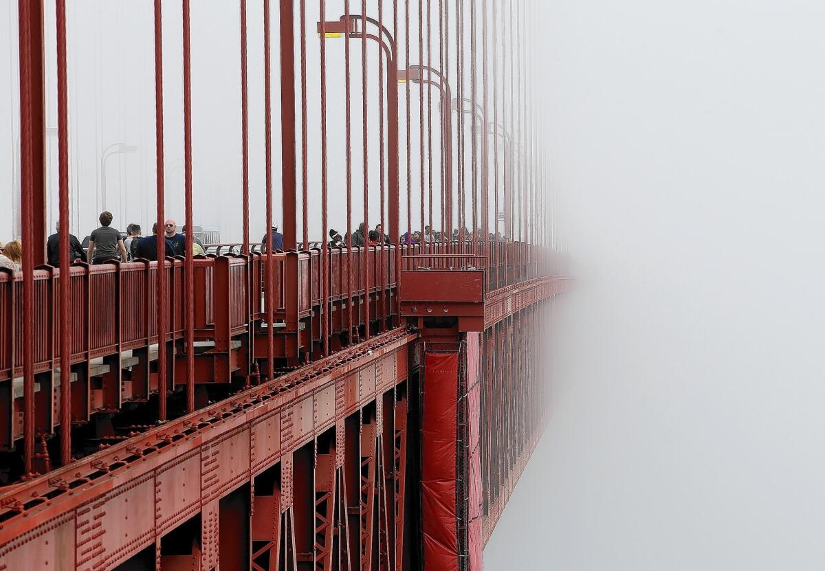 The Golden Gate Bridge disappears into the fog. The bridge district's board of directors voted unanimously to approve a $76-million funding package to build a net suicide barrier on the iconic span.
