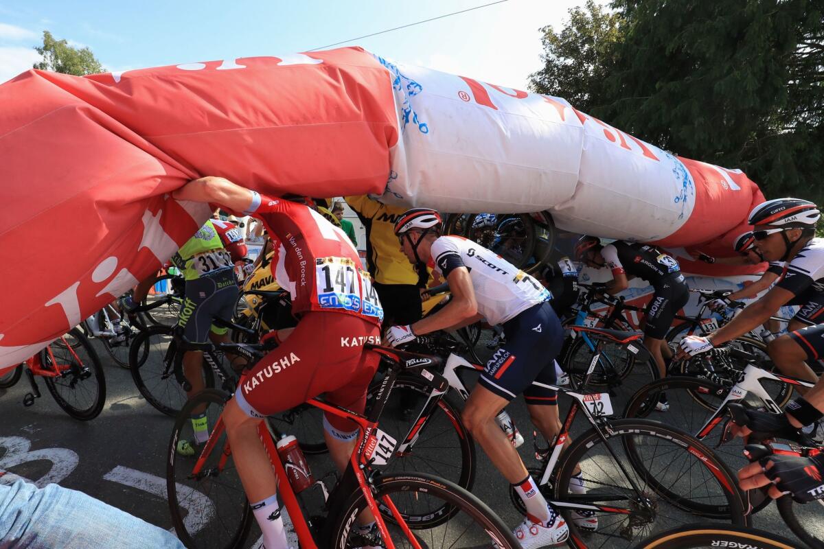Alberto Contador, left, Jurgen Van den Broeck and Stef Clement try to pedal under a deflated arch Friday at the Tour de France.