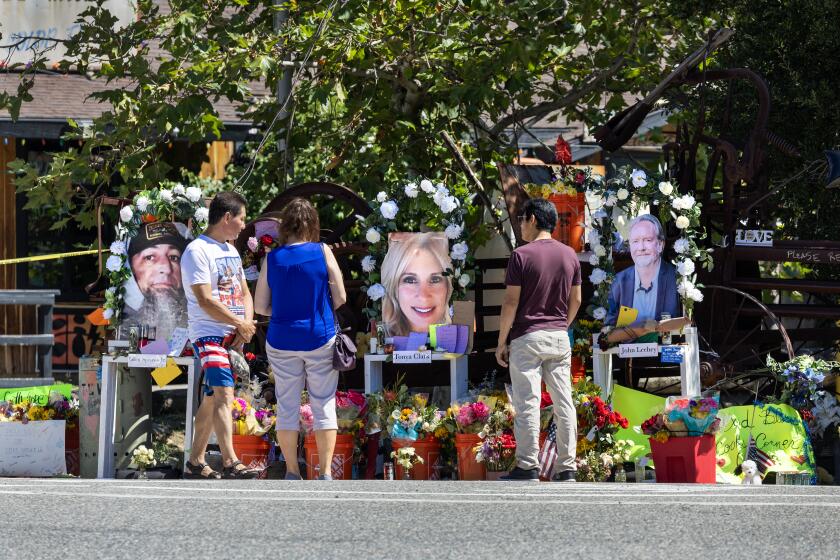 Trabuco Canyon, CA - August 29: People pay their respects at a growing memorial to the mass shooting victims after John Snowling, a retired Ventura police sergeant, killed three people and wounded six others at Cook's Corner in Trabuco Canyon Tuesday, Aug. 29, 2023. The shooting victims were Glen Sprowl Jr., left, 53, of Stanton, Tonya Clark, middle, 49, of Scottsdale, Ariz., and John Leehey, right, 67, of Irvine. (Allen J. Schaben / Los Angeles Times)