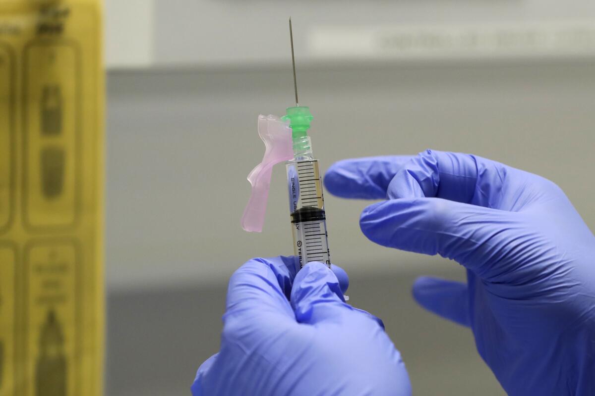  la enfermera jefe de investigación clínica Ajithkumar Sukumaran prepara una posible vacuna de COVID-19 