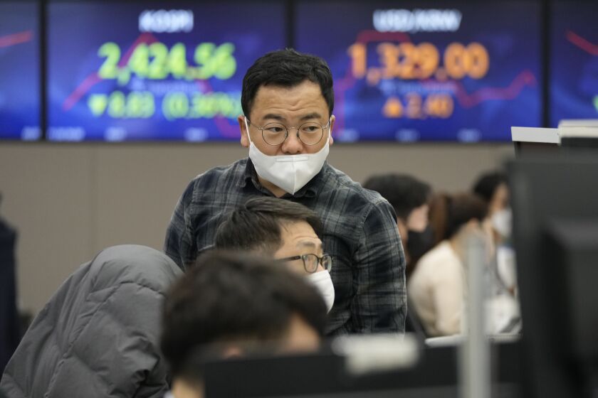 Currency traders watch monitors at the foreign exchange dealing room of the KEB Hana Bank headquarters in Seoul, South Korea, Wednesday, Nov. 30, 2022. Asian shares were mostly lower Wednesday ahead of a closely watched speech by the Federal Reserve chief that may give clues about future interest rate hikes. (AP Photo/Ahn Young-joon)