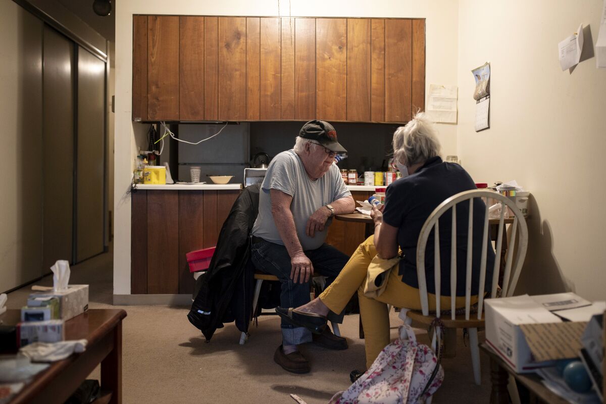 Kathleen McAuliffe, a home care worker, helps client John Gardner with his weekly chores.