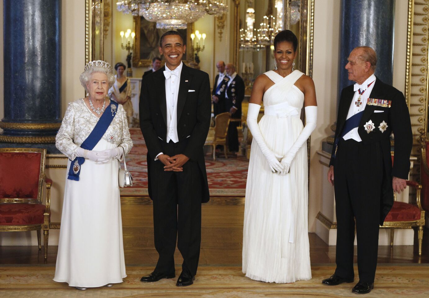 In this May 24, 2011, photo with Queen Elizabeth II, President Barack Obama and Prince Philip at Buckingham Palace, Michelle Obama is wearing a white gown by American designer Tom Ford, who has a home in London.