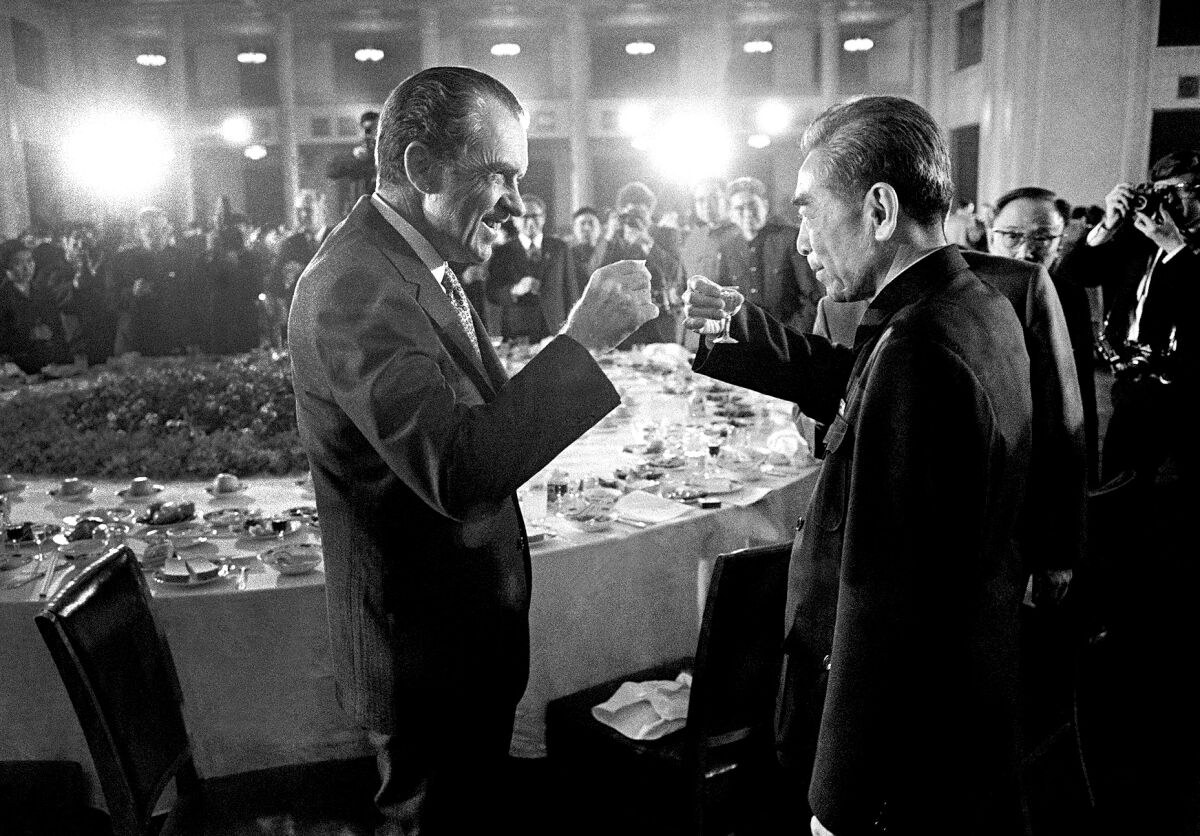 President Nixon and Chinese Premier Zhou Enlai toasting at a banquet in a black and white photo