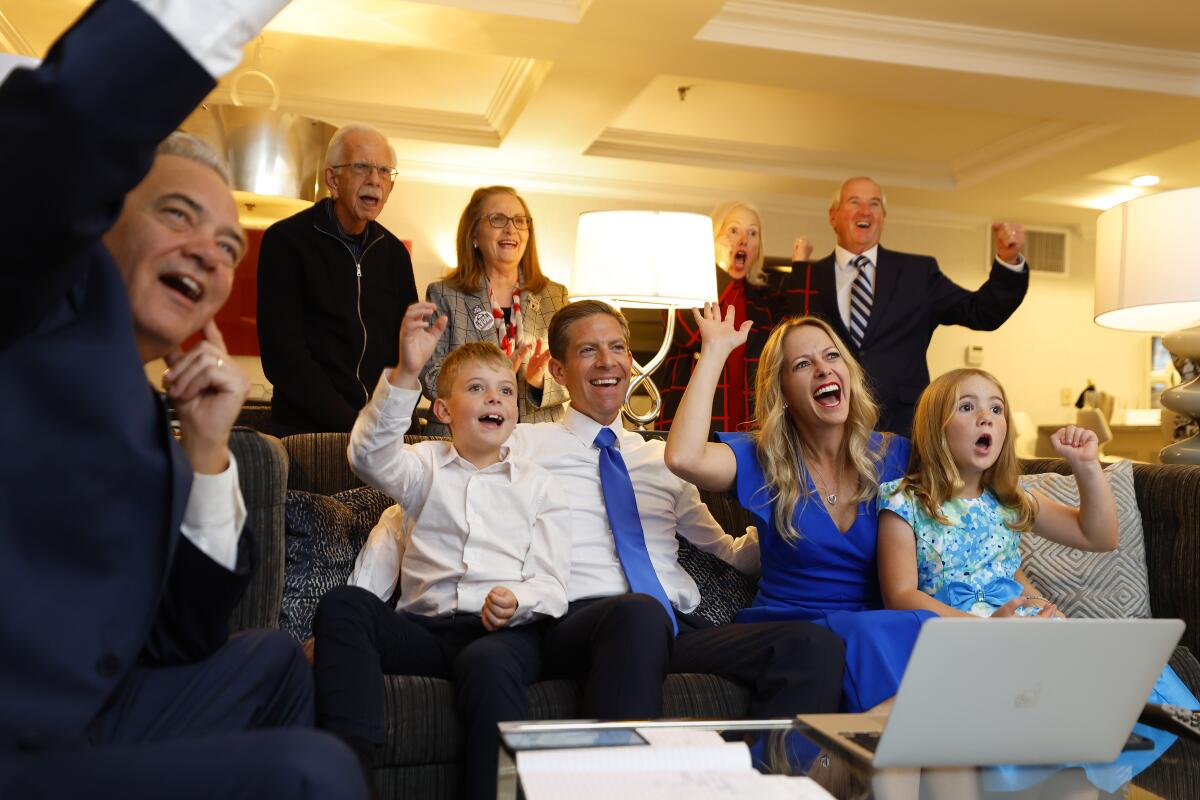 Rep. Mike Levin, center, watches results come in with his family on election night on Tuesday in Del Mar. 