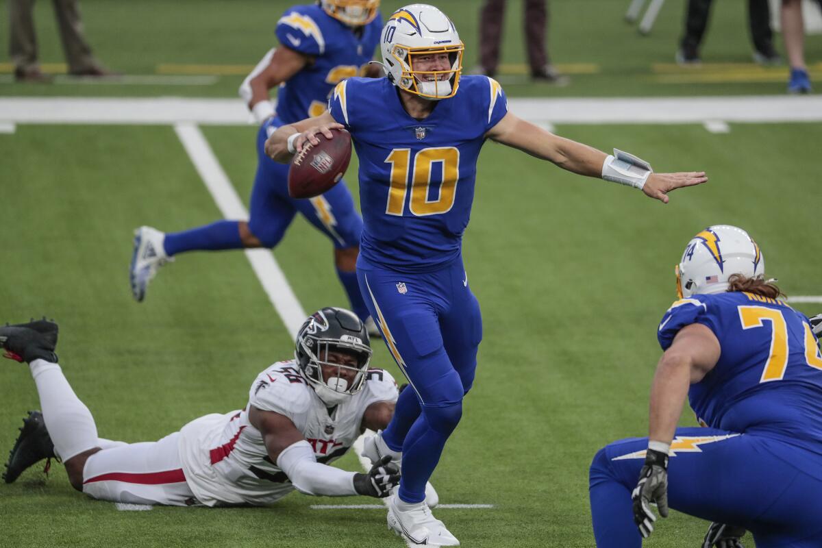 Chargers quarterback Justin Herbert avoids being tackles by Atlanta Falcons defensive end Dante Fowler Jr.