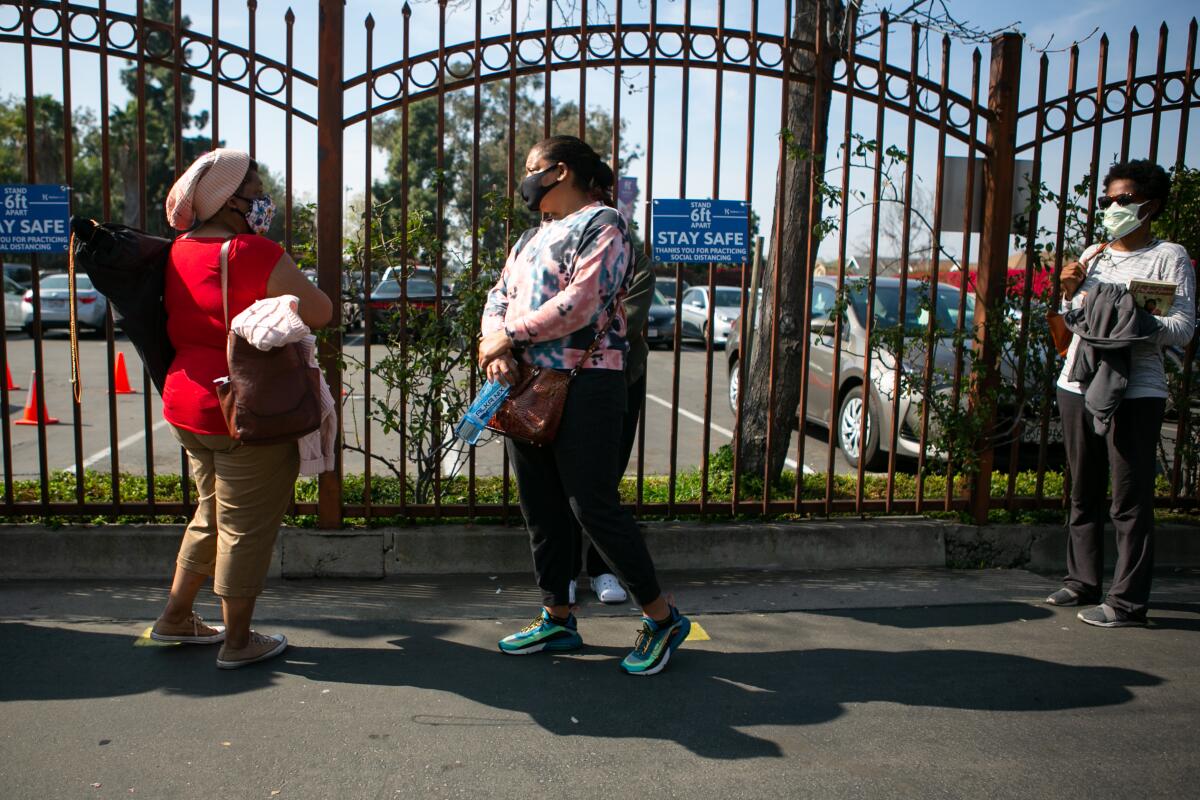 People line up outside the fence at Kedren Health in South Los Angeles.