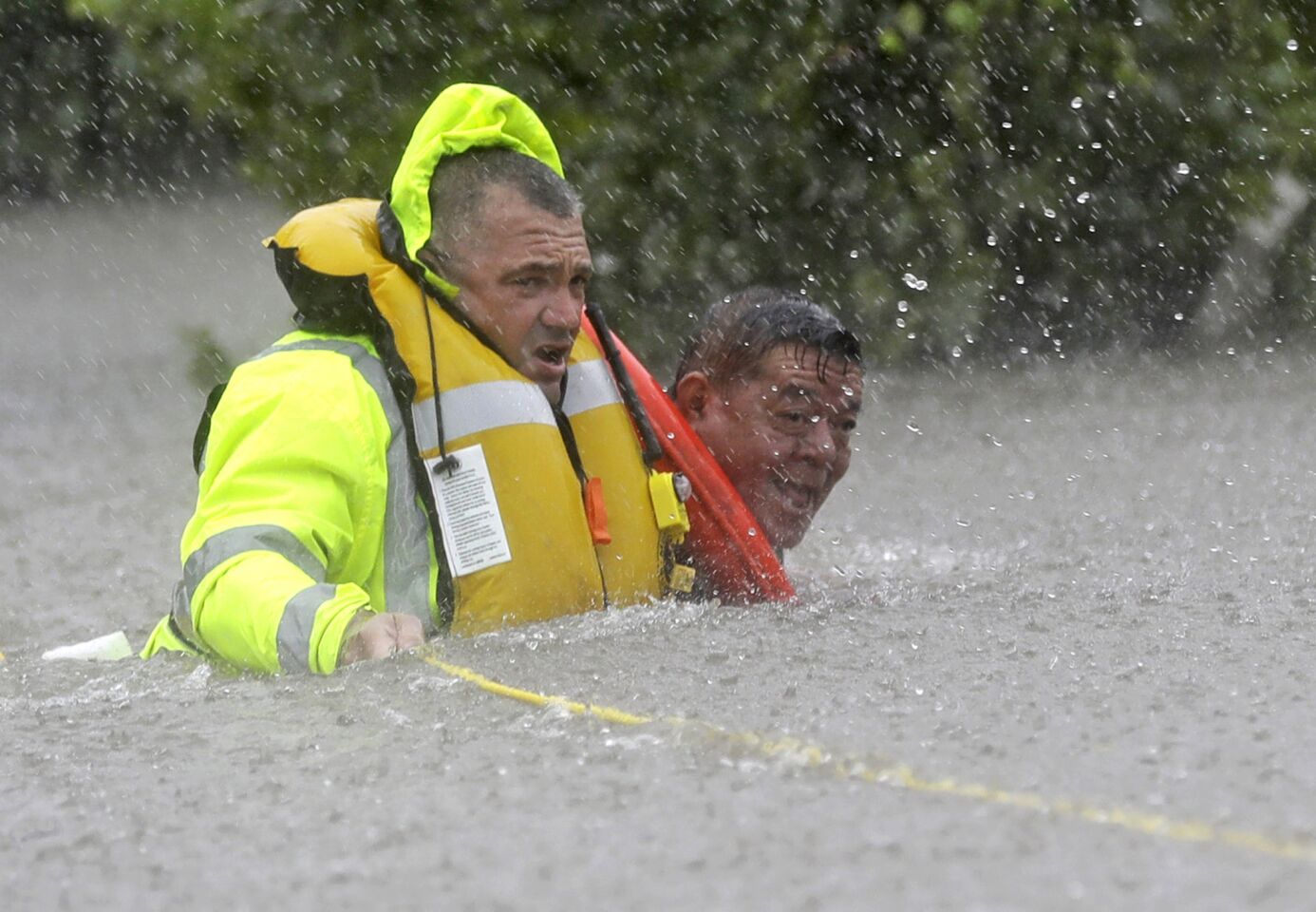 Wilford Martinez, right, is rescued from his flooded car by Harris County Sheriff's Department Richard Wagner along Interstate 610 in Houston, Texas.