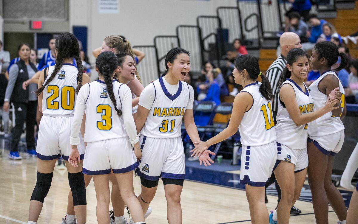 The Marina girls' basketball team celebrates after beating Lompoc on Tuesday.