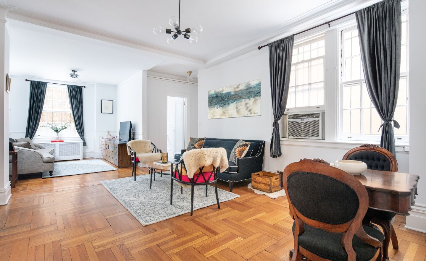 The two-bedroom, one-bathroom apartment features restored hardwood floors and original wainscoting across 1,100 square feet.