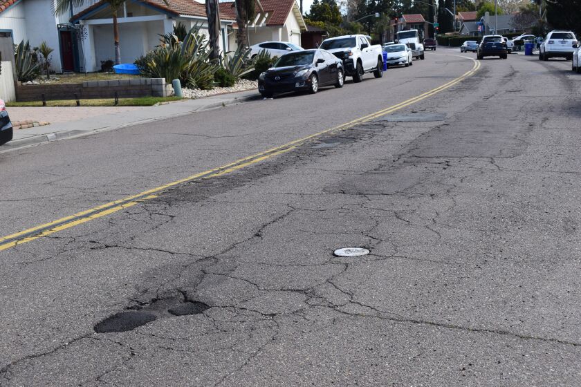 Poblado Road in Rancho Bernardo is filled with potholes, long cracks and crumbling asphalt.