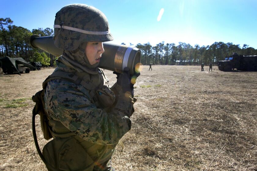 Marine Sgt. Mindy Vuong, a research volunteer in the experimental Ground Combat Element Integrated Task Force based at Camp Lejeune, N.C., carries an artillery shell weighing about 100-pounds.