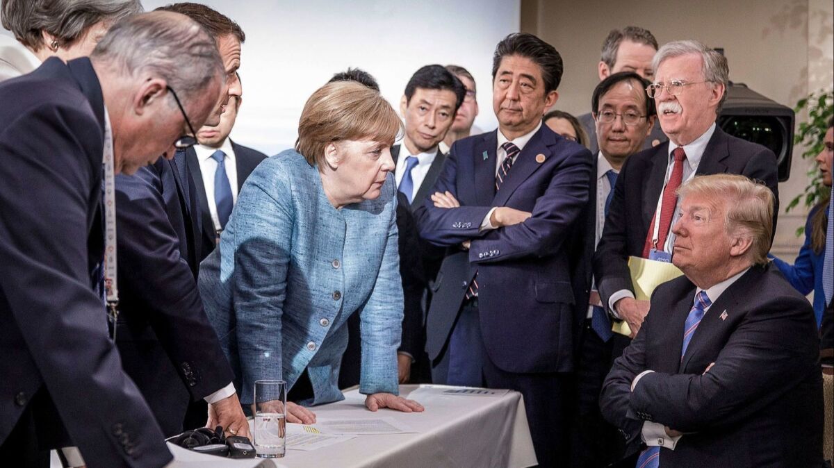 In a German government photo, German Chancellor Angela Merkel leans in while speaking to President Trump during a gathering of G-7 leaders and aides Saturday in Canada.