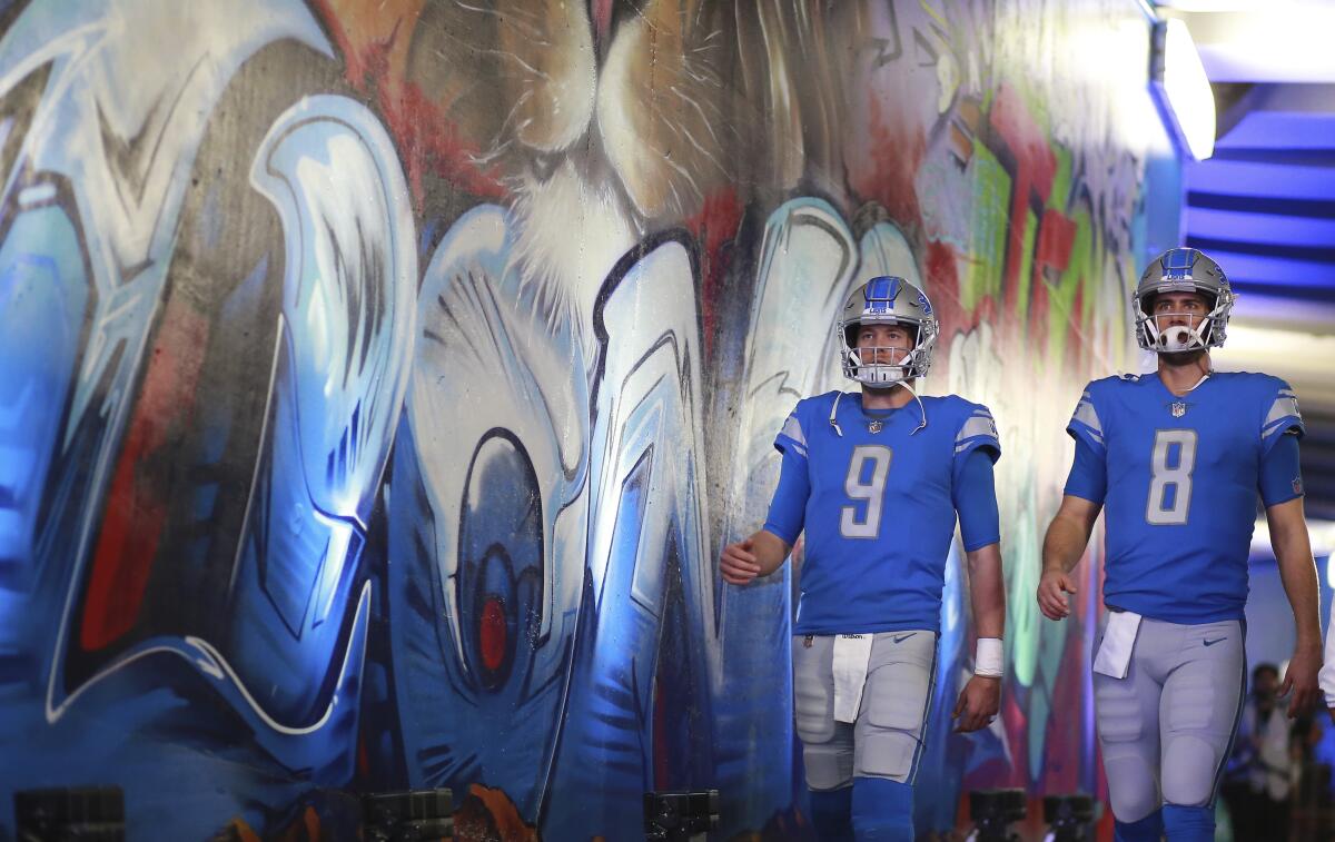 Detroit Lions quarterbacks Matthew Stafford and Matt Cassel walk together.