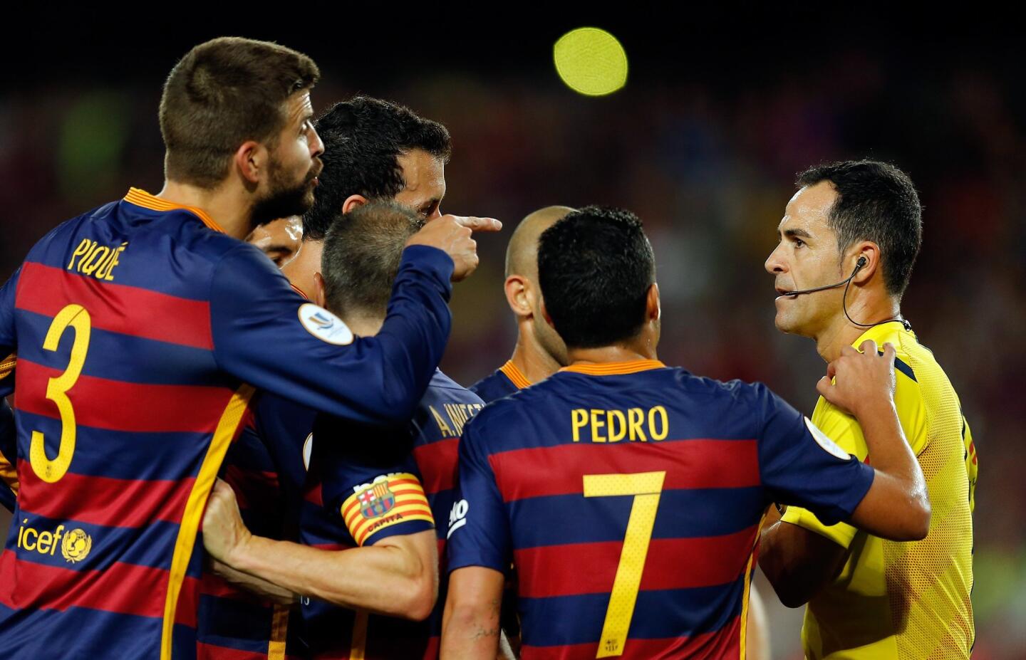 Barcelona's Gerard Pique, left, gestures to Referee Velasco Carballo, right, and his shown a red card during a second leg Spanish Super Cup soccer match between FC Barcelona and Athletic Bilbao at the Camp Nou stadium in Barcelona, Spain, Monday, Aug.17, 2015. (AP Photo/Manu Fernandez)